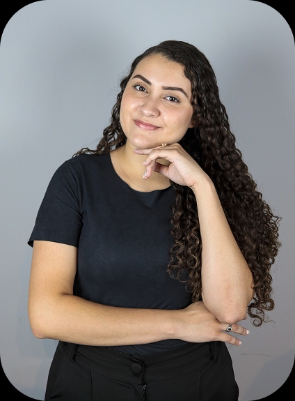 mulher sentada na poltrona de frente com microfone e sorrindo